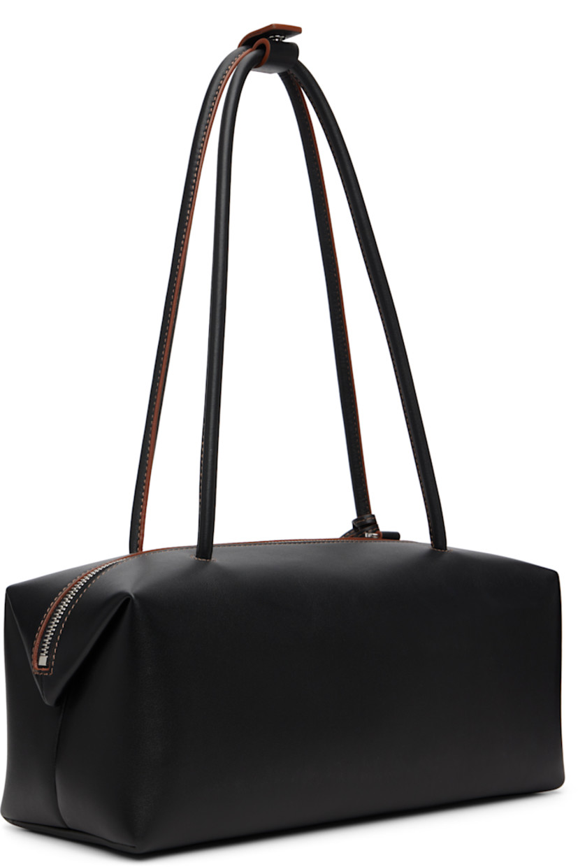 Buffed calfskin shoulder bag.

· Press-stud tab at rolled shoulder straps
· Detachable leather sheathed keys with logo plaque
· Logo stamp at face
· Padlock at side
· Bumper pads at base
· Zip closure
· Patch pocket at goatskin suede interior
· H5" x W11.5" x D5"

Supplier color: Black