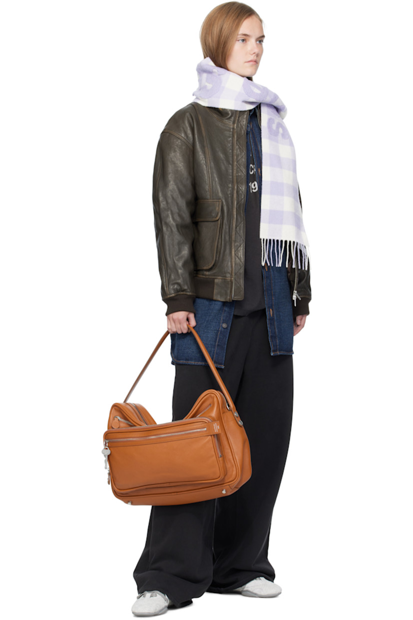 Grained calfskin shoulder bag.

· Fixed carry handle
· Adjustable and detachable shoulder strap
· Logo stamp, key charm, and zip pockets at face
· Rivet and patch pocket at back face
· Rivets at sides 
· Bumper studs at base 
· Two-way zip closure
· Patch pocket at interior 
· Buffed faux-leather lining
· Logo-engraved silver-tone hardware 
· H11" x W16" x D4.5"

Supplier color: Cognac brown