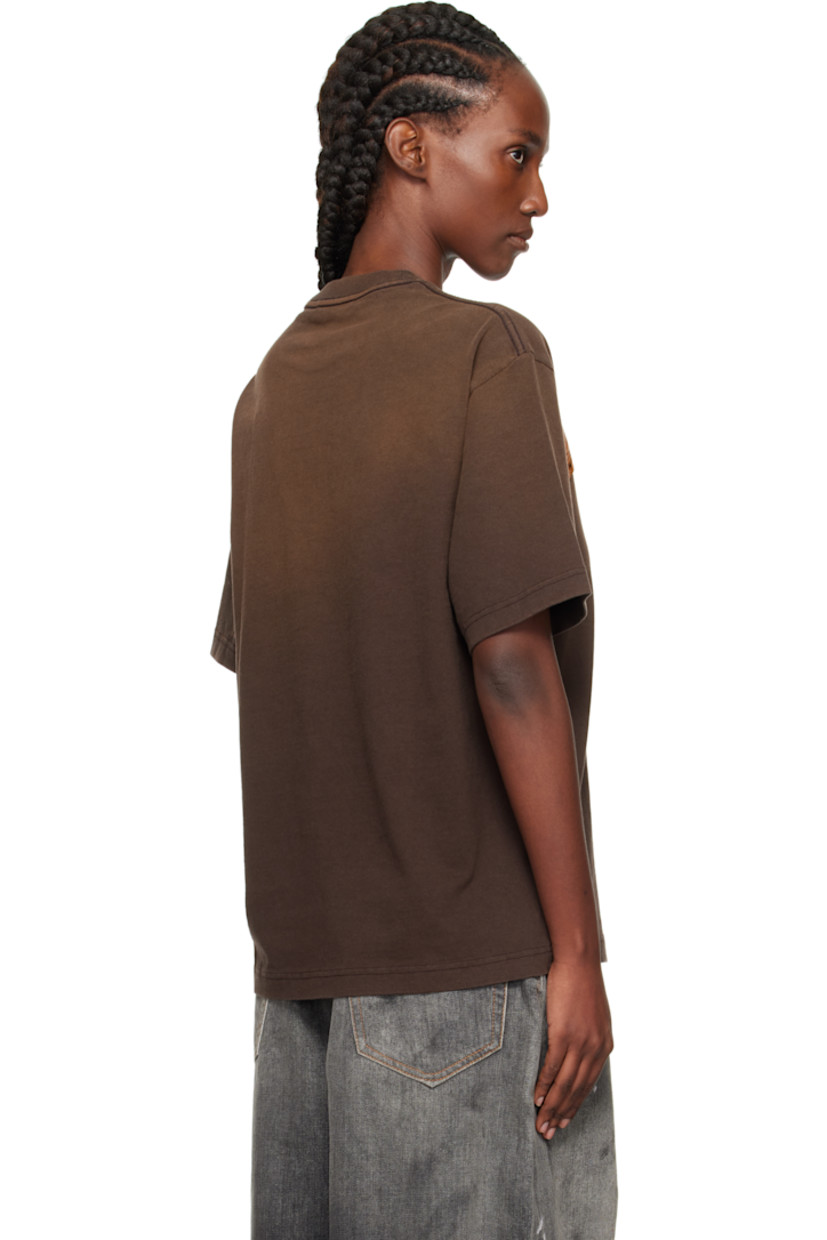 Organic cotton jersey T-shirt.

· Fading throughout
· Rib-knit crewneck
· Logo and text appliqué at front
· Graphic and text printed at front
· Dropped shoulders

Supplier color: Dark brown
