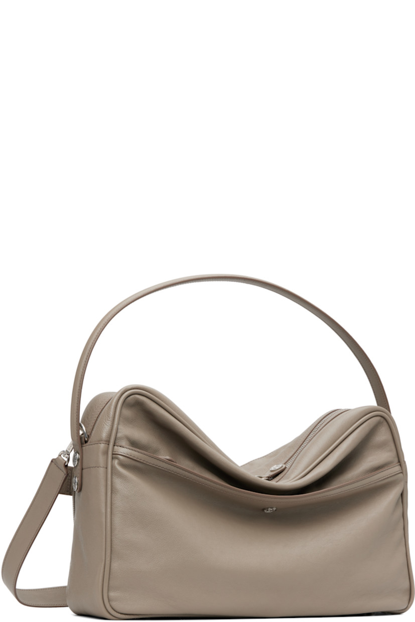 Grained calfskin shoulder bag.

· Fixed carry handle
· Adjustable and detachable shoulder strap
· Logo stamp, key charm, and zip pockets at face
· Rivet and patch pocket at back face
· Rivets at sides 
· Bumper studs at base 
· Two-way zip closure
· Patch pocket at interior 
· Buffed faux-leather lining
· Logo-engraved silver-tone hardware 
· H11" x W16" x D4.5"

Supplier color: Taupe beige