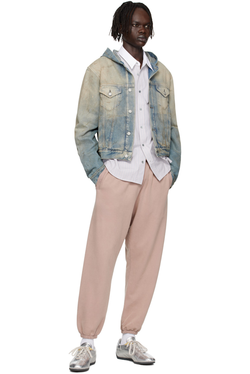 Non-stretch organic cotton denim jacket.

· Discoloration, smudging, and subtle distressing throughout
· Integrated hood
· Button closure
· Flap pockets at chest
· Welt pockets at waist
· Cropped hem
· Buttoned cuffs
· Adjustable button tabs at back hem
· Logo-engraved silver-tone hardware
· Contrast stitching in tan

Supplier color: Mid blue