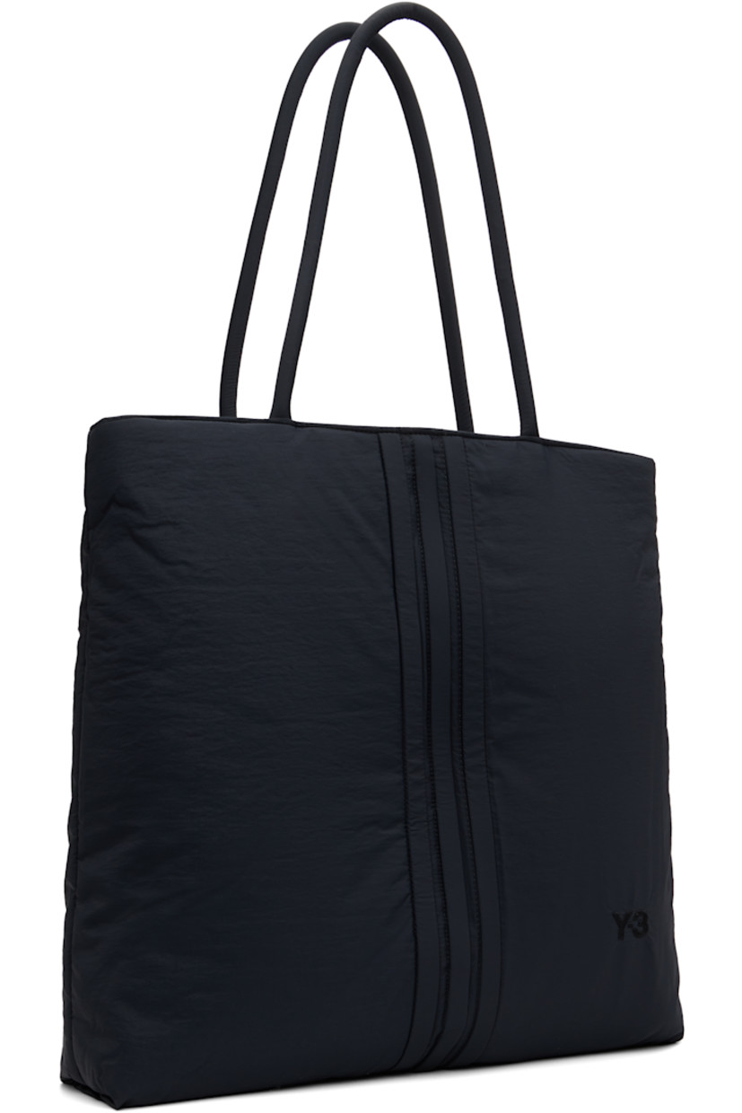 Padded recycled nylon-blend taffeta tote. 

· Twin rolled shoulder straps
· Embroidered logo at face
· Signature stripes at face and back
· Zip closure
· D-ring and zip pocket at interior 
· Twill lining
· Logo-engraved hardware
· H17" x W17" x D3.5"/ 40 L 

Supplier color: Black