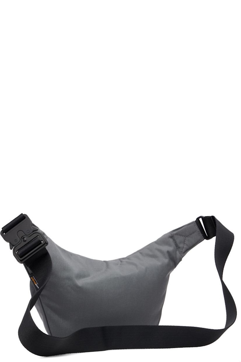 Padded CORDURA® nylon canvas belt bag.

· Adjustable crossbody strap
· Zip pocket at face
· Logo bonded at face
· Logo flag at outer side
· Zip closure
· Zip pocket at interior
· Satin twill lining
· H7" x W11" x D3.75"

Supplier color: Granite