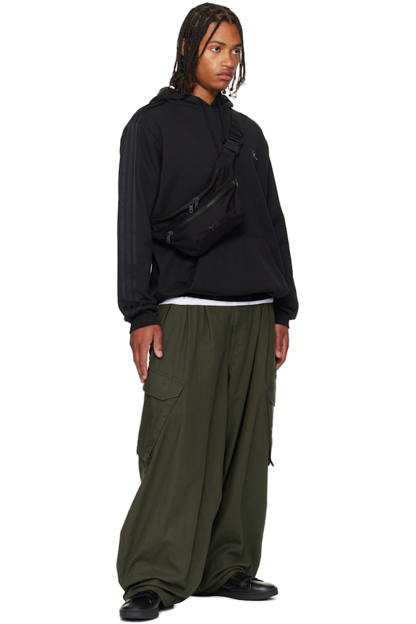 Padded CORDURA® nylon canvas belt bag.

· Adjustable crossbody strap
· Zip pocket at face
· Logo bonded at face
· Logo flag at outer side
· Zip closure
· Zip pocket at interior
· Satin twill lining
· H7" x W11" x D3.75"

Supplier color: Black