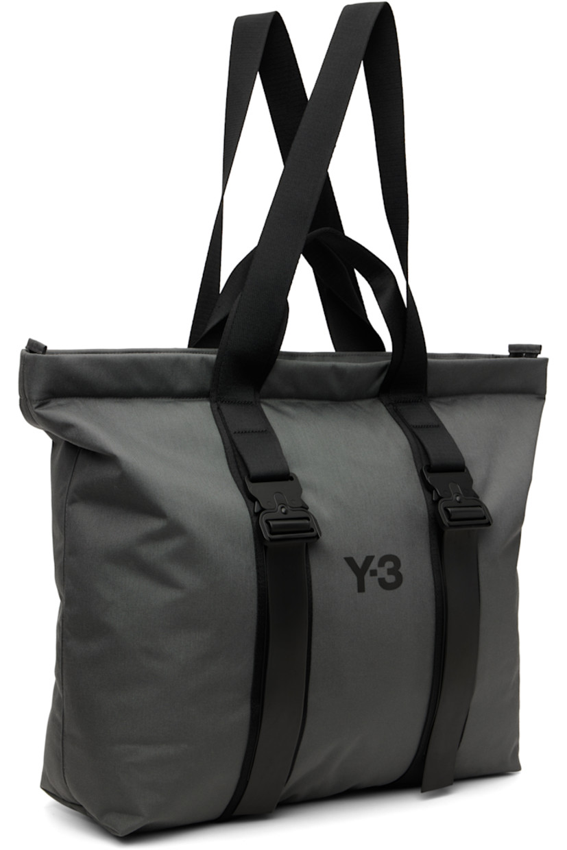 Canvas tote.

· Fixed carry handles and shoulder straps
· Bonded logo and press-release straps at face
· Two-way zip closure
· D-ring and zip pocket at interior
· Laptop compartment
· Twill lining
· H18" x W21" x D6"

Supplier color: Granit
