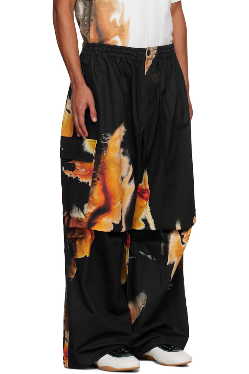 Cotton- and hemp-blend twill cargo pants.

· Loose-fit
· Graphics printed throughout
· Drawstring at elasticized waistband
· Four-pocket styling
· Zip fly
· Pleats at knees
· Drawstring at cuffs
· Cargo pocket at outseams
· Logo bonded at cargo pocket

Each item is unique. Please note coloration may vary.

Supplier color: Black
