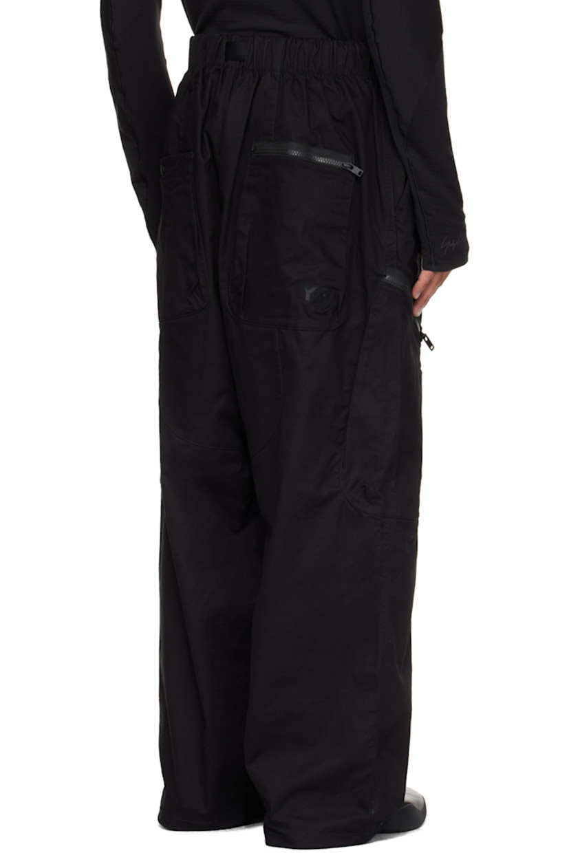 Cotton-blend twill cargo pants.

· Integrated press-release belt at elasticized waistband
· Belt loops
· Four-pocket styling
· Zip fly
· D-ring at front waistband
· Bungee-style drawstring at cuffs
· Welt pocket at outseam
· Zip pocket at outseams

Supplier color: Black