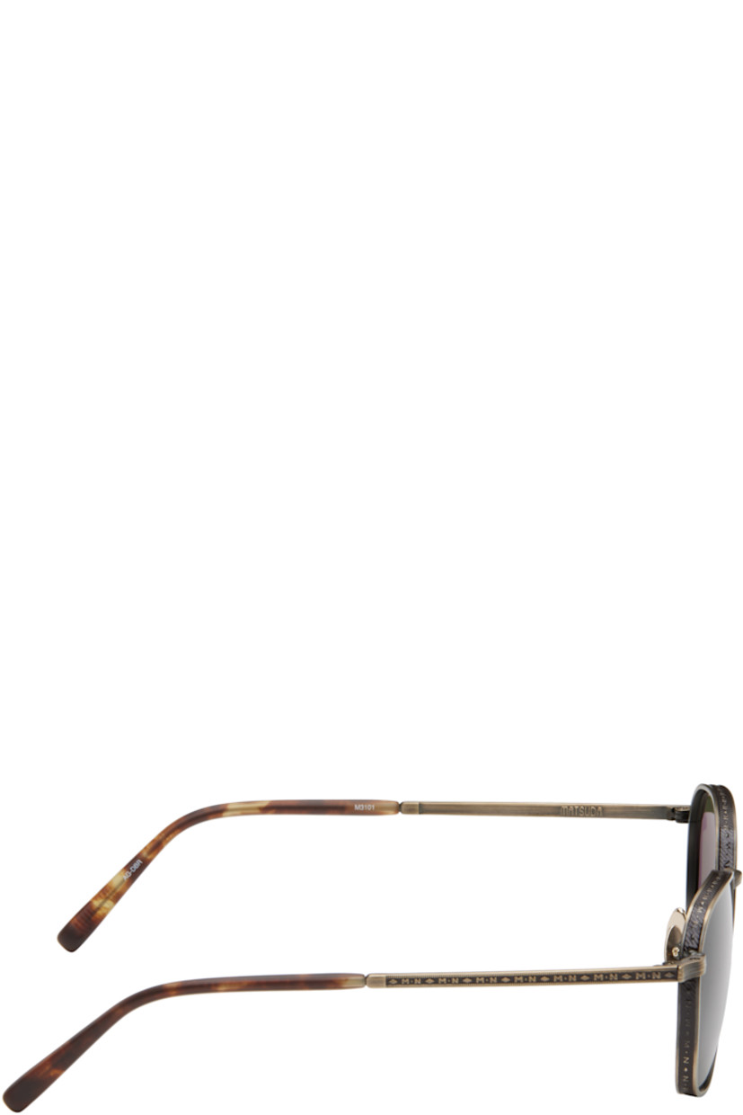Hexagonal titanium-frame sunglasses in antiqued gold tone. Hand-lacquered detailing, logo pattern, and engraved detailing throughout.

· Lightweight
· Green lenses
· 100% UVA/UVB protection 
· Adjustable titanium nose pads
· Tortoiseshell acetate temple tips
· Includes case
· Size: 52.21 145

Supplier color: Antique gold/Dark brown
