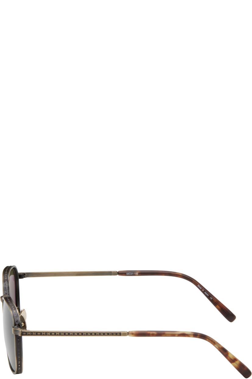 Hexagonal titanium-frame sunglasses in antiqued gold tone. Hand-lacquered detailing, logo pattern, and engraved detailing throughout.

· Lightweight
· Green lenses
· 100% UVA/UVB protection 
· Adjustable titanium nose pads
· Tortoiseshell acetate temple tips
· Includes case
· Size: 52.21 145

Supplier color: Antique gold/Dark brown