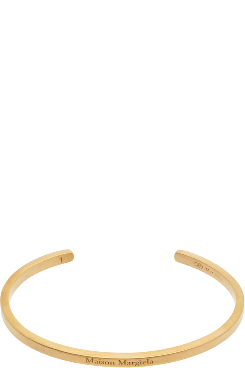 Open cuff bracelet in gold-tone sterling silver. Logo engraved at face.

Supplier color: Yellow gold plating burattato