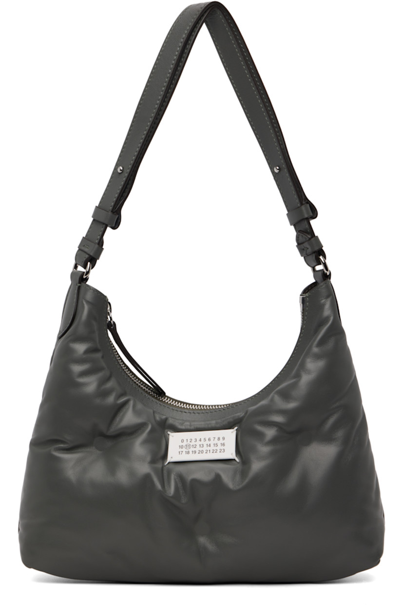 Tufted grained sheepskin shoulder bag.

· Adjustable shoulder strap
· Logo patch and white stitching at face 
· Zip closure
· Zip pocket at interior 
· Plain-woven lining 
· Silver-tone hardware
· H6" x W10.5" x D3"

Supplier color: Caillou