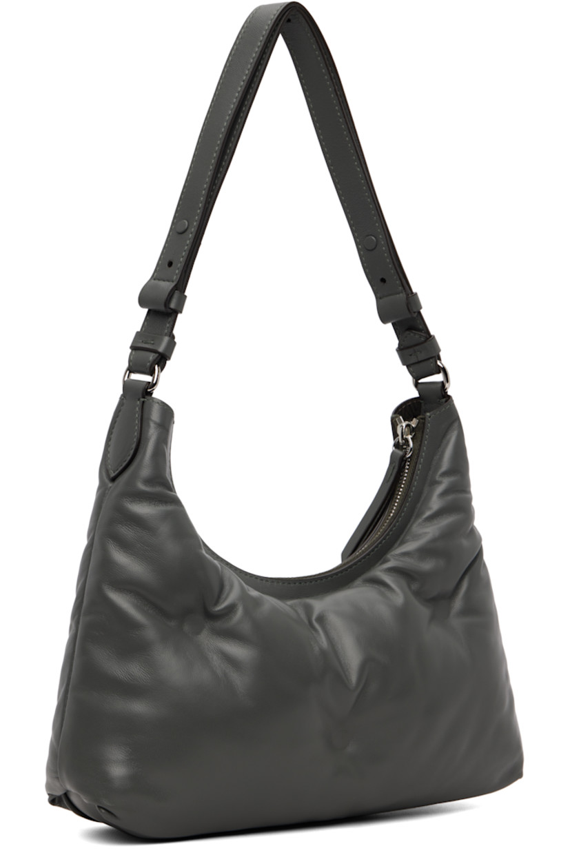Tufted grained sheepskin shoulder bag.

· Adjustable shoulder strap
· Logo patch and white stitching at face 
· Zip closure
· Zip pocket at interior 
· Plain-woven lining 
· Silver-tone hardware
· H6" x W10.5" x D3"

Supplier color: Caillou