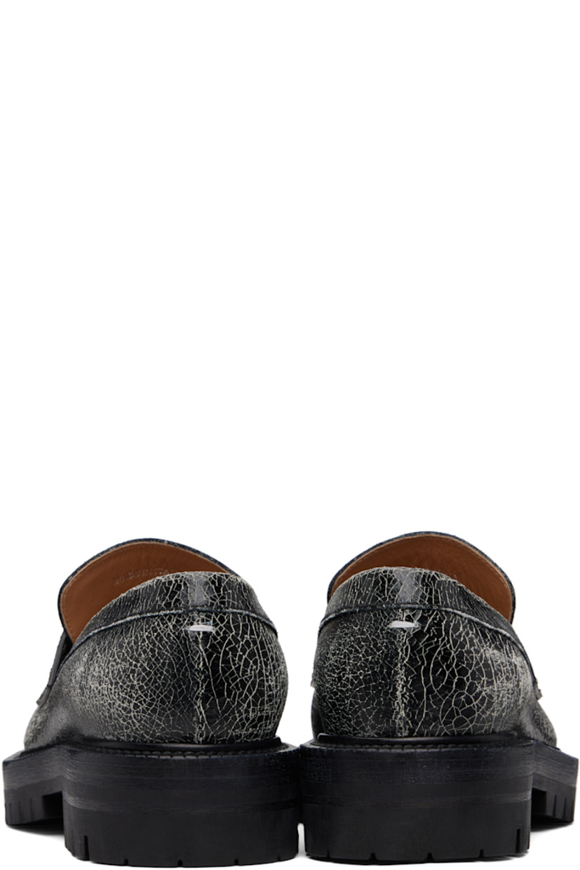 Cracked calfskin loafers.

· Square cleft toe
· Strap with cutout at vamp
· White stitching at heel collar
· Buffed sheepskin lining
· Serrated edge at welt
· Treaded rubber sole

Supplier color: Black/White