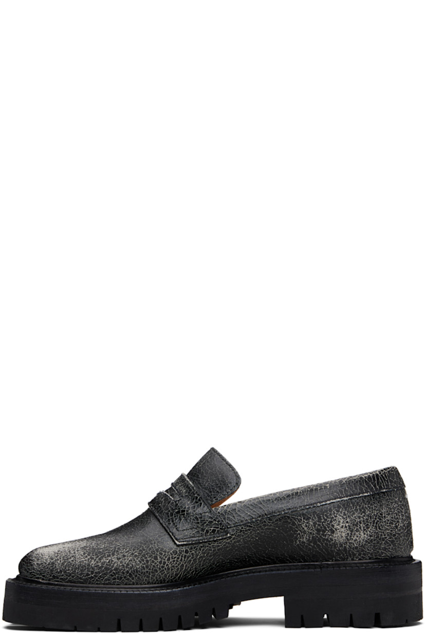 Cracked calfskin loafers.

· Square cleft toe
· Strap with cutout at vamp
· White stitching at heel collar
· Buffed sheepskin lining
· Serrated edge at welt
· Treaded rubber sole

Supplier color: Black/White