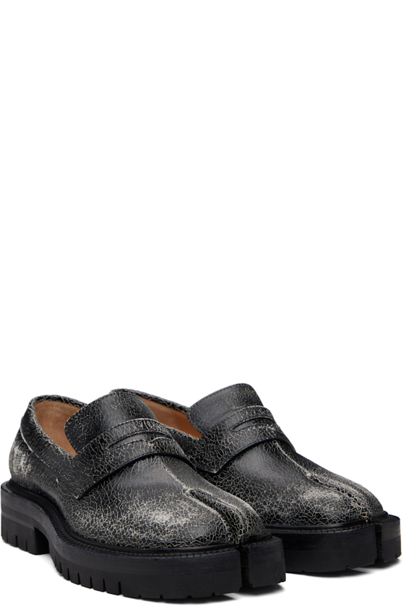 Cracked calfskin loafers.

· Square cleft toe
· Strap with cutout at vamp
· White stitching at heel collar
· Buffed sheepskin lining
· Serrated edge at welt
· Treaded rubber sole

Supplier color: Black/White
