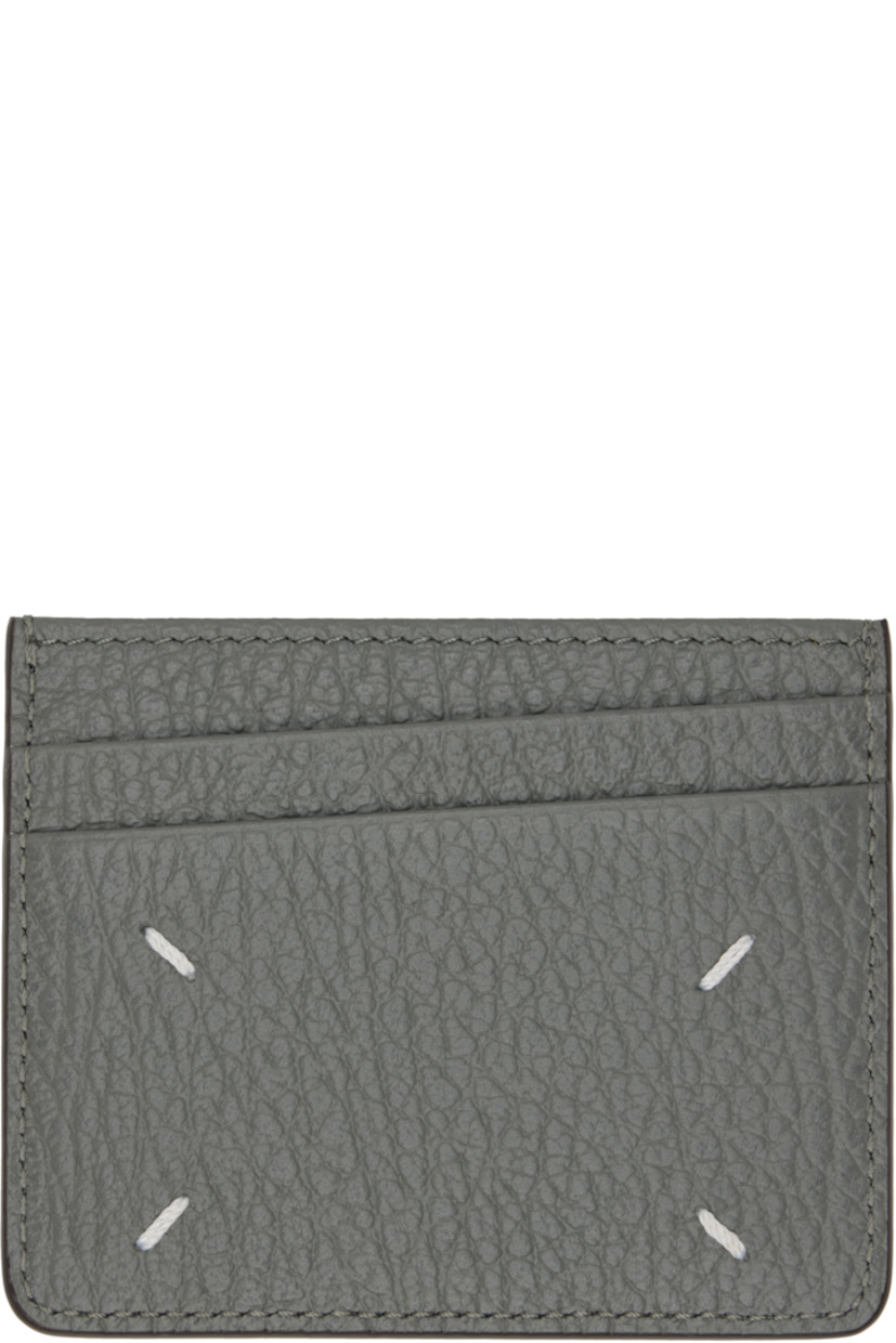 Pebble-grained calfskin card holder. 

· White stitching at back face
· Five card slots
· Central note slot
· Canvas lining
· H3.25" x W4"

Supplier color: Caillou