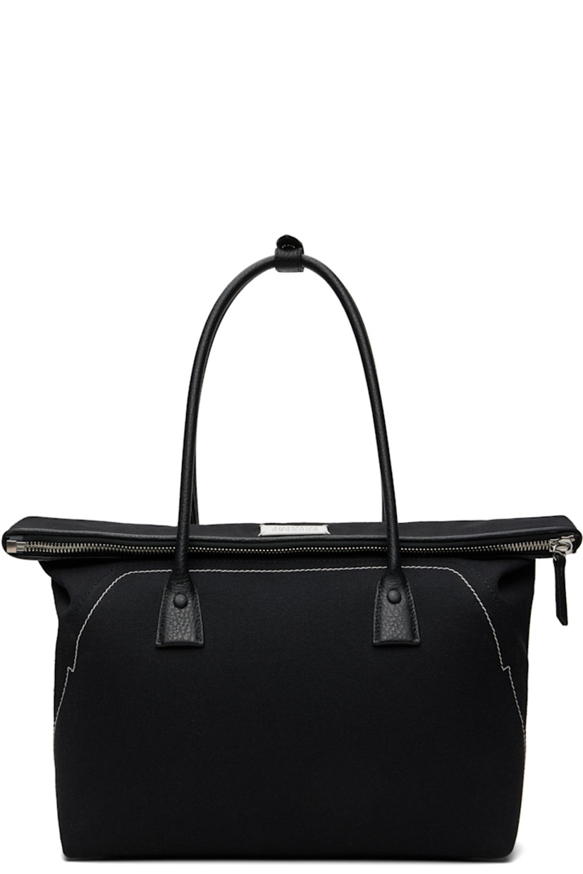 Canvas and grained calfskin shoulder bag.

· Press-stud tab at rolled shoulder straps
· Logo patch at face
· Topstitching at face and back face
· Bumper studs at base
· Foldover zip closure
· Zip pocket at interior
· Twill lining
· H13.5" x W15" x D4"

Supplier color: Black