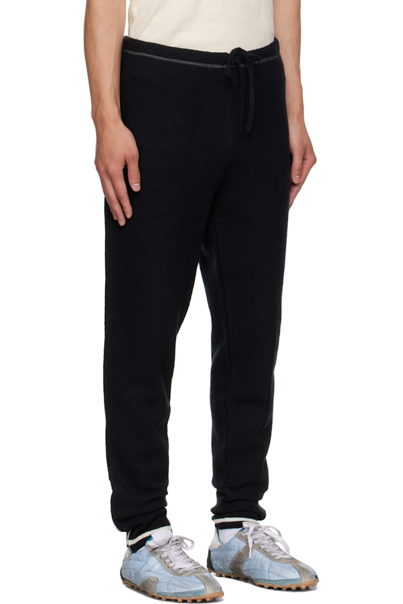 Wool melton track pants.

· Tapered leg
· Drawstring at elasticized waistband
· Single-pocket styling
· Pinched seam at legs
· Zip vent at striped rib-knit cuffs
· White stitching at back

Supplier color: Black/Off white