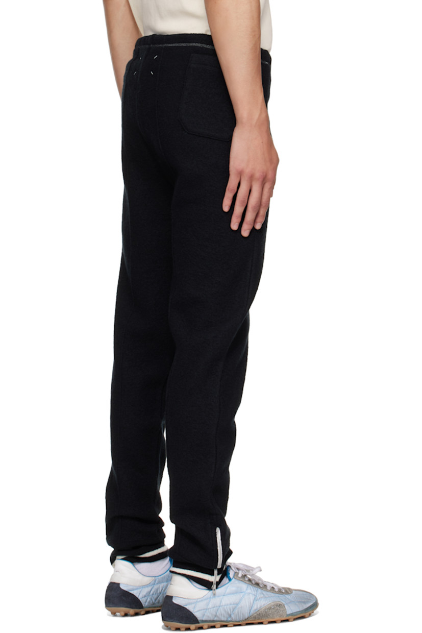 Wool melton track pants.

· Tapered leg
· Drawstring at elasticized waistband
· Single-pocket styling
· Pinched seam at legs
· Zip vent at striped rib-knit cuffs
· White stitching at back

Supplier color: Black/Off white