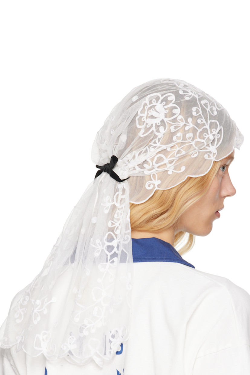 Nylon mesh veil in white. 

· Floral pattern embroidered throughout
· Scalloped edges
· Velvet bow accent at back 
· H20.5" x W11" 

This item is part of a limited run of 16.

Supplier color: White/White