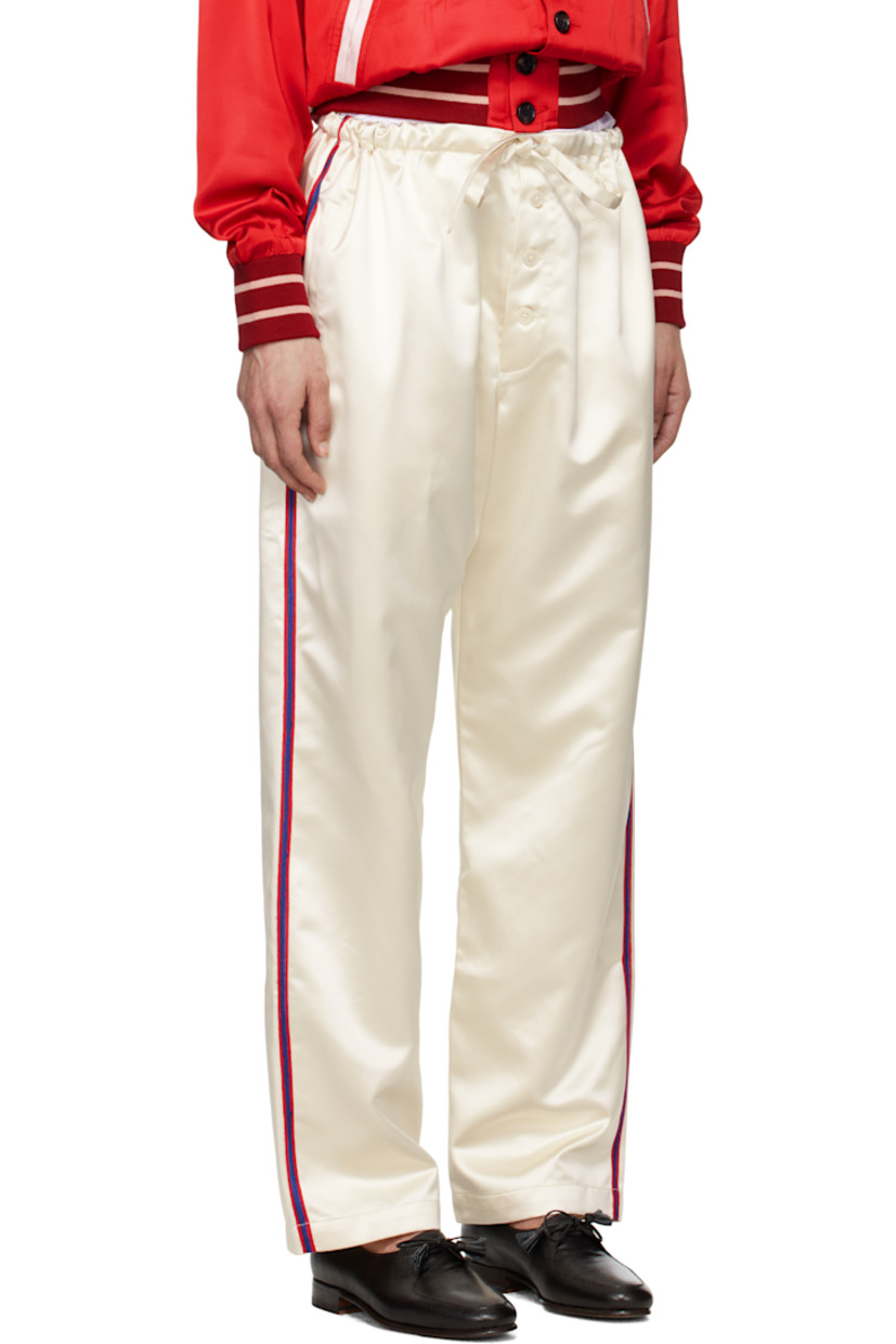 Polyester satin trousers. 

· Self-tie drawstring at waistband
· Three-pocket styling
· Button fly
· Striped trim at outseams and back pocket

This item is part of a limited run of 63.

Supplier color: Cream