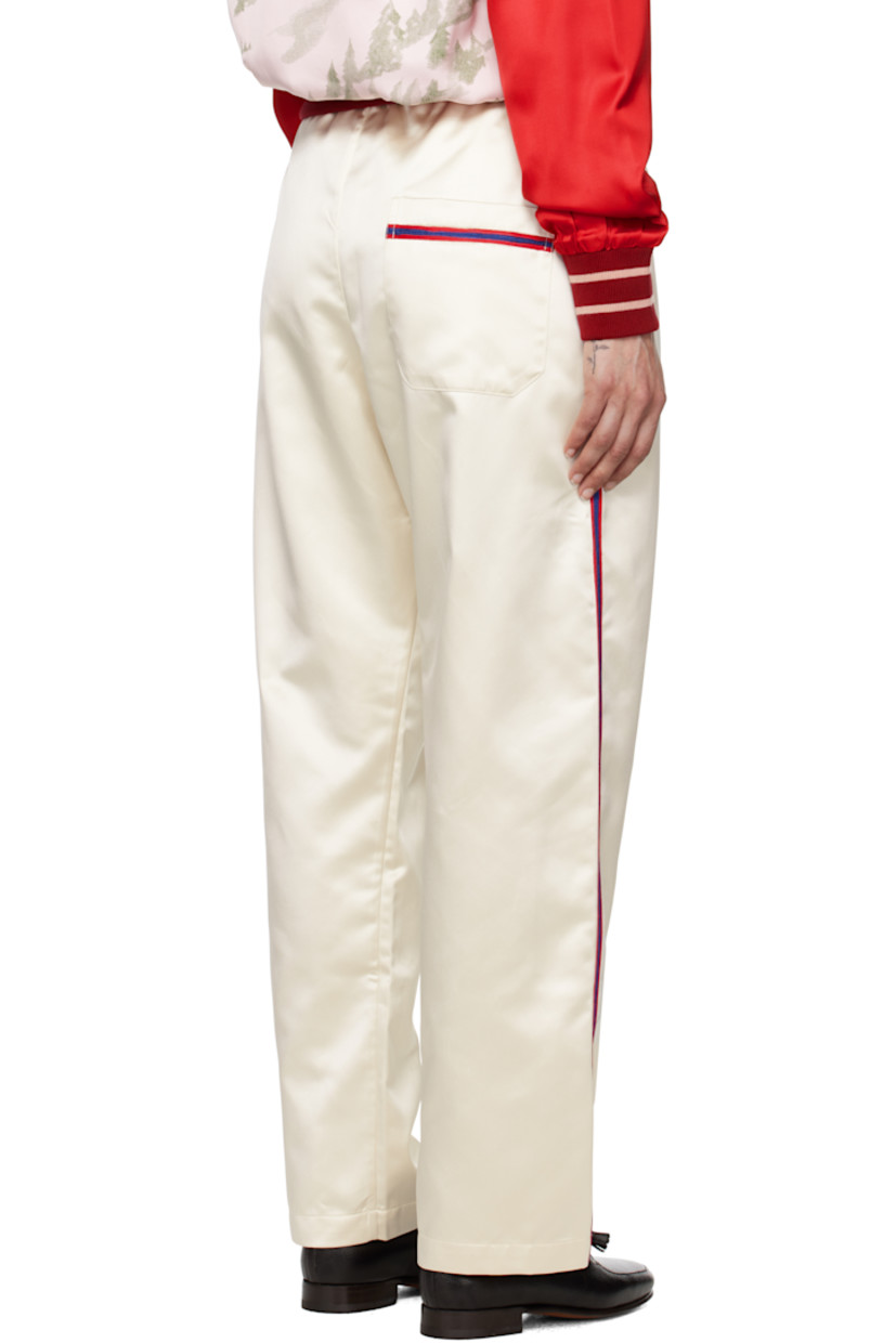 Polyester satin trousers. 

· Self-tie drawstring at waistband
· Three-pocket styling
· Button fly
· Striped trim at outseams and back pocket

This item is part of a limited run of 63.

Supplier color: Cream