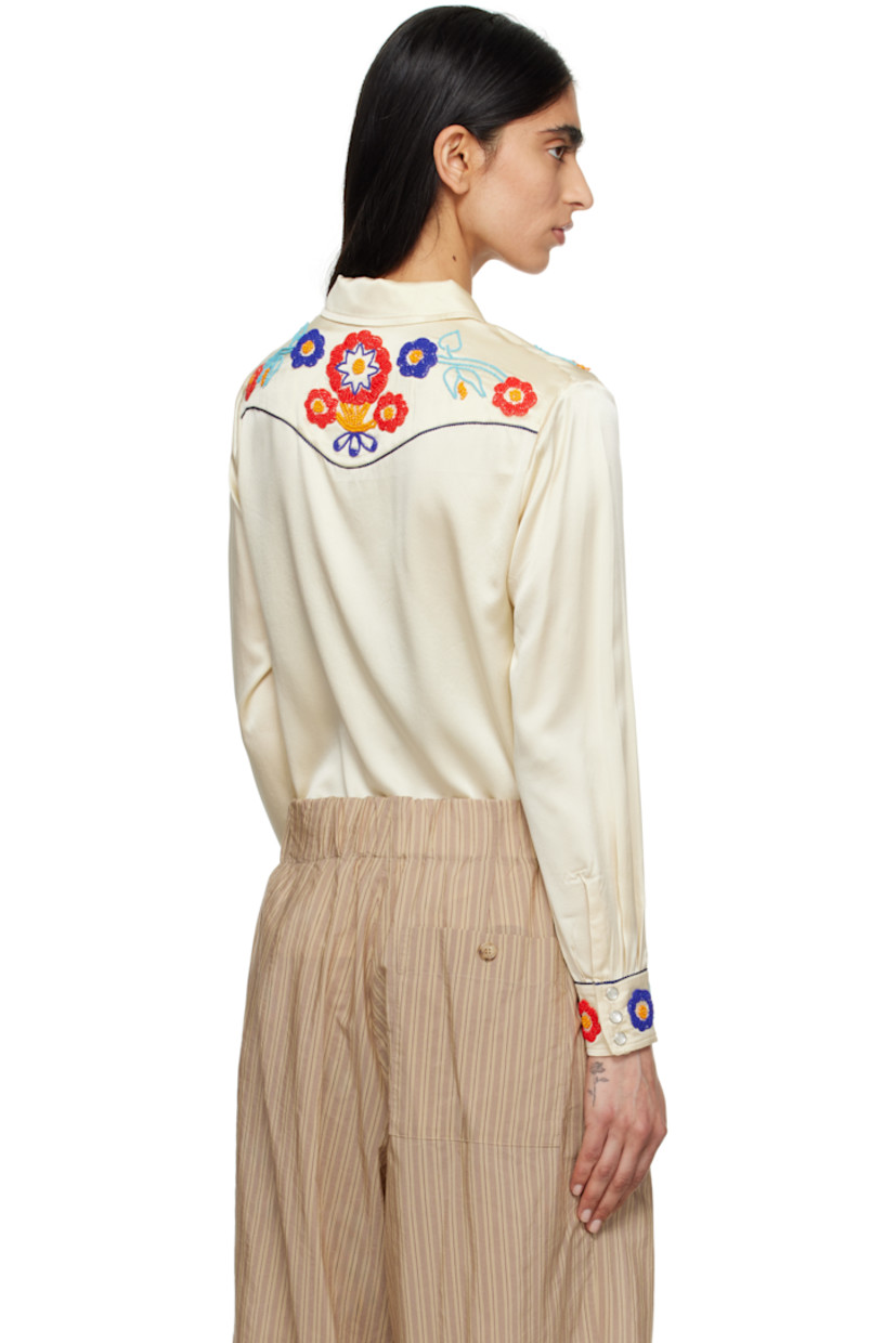 Silk satin shirt. Piping and beaded detailing throughout. 

· Spread collar
· Press-stud closure
· Western yoke at front and back
· Welt pockets
· Pleats at buttoned barrel cuffs

This item is part of a limited run of 72.

Supplier color: Cream multi