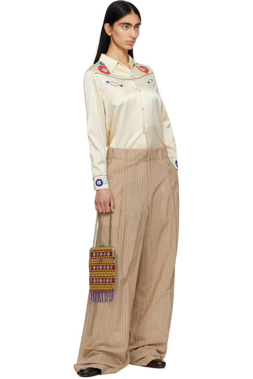 Silk satin shirt. Piping and beaded detailing throughout. 

· Spread collar
· Press-stud closure
· Western yoke at front and back
· Welt pockets
· Pleats at buttoned barrel cuffs

This item is part of a limited run of 72.

Supplier color: Cream multi