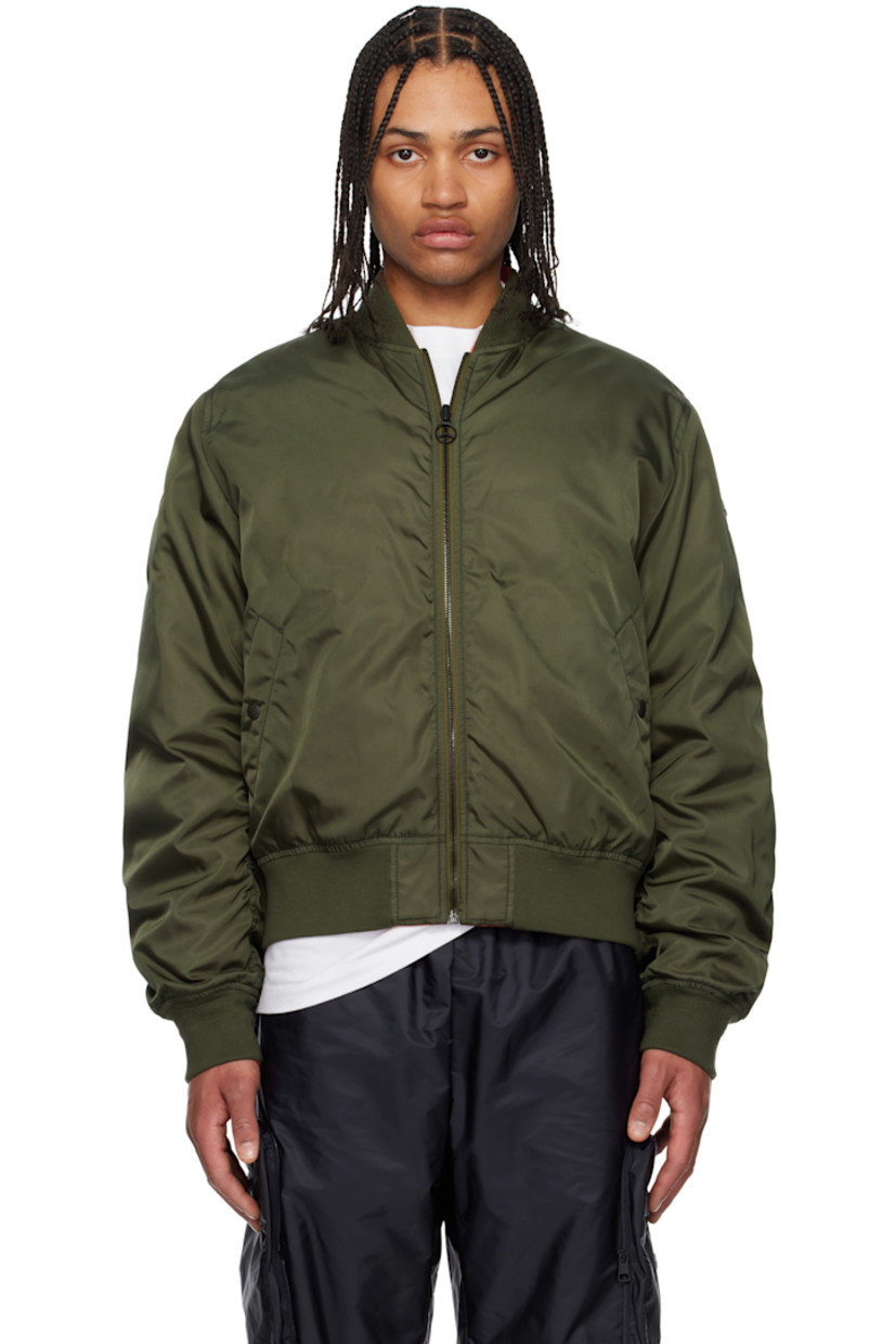 Reversible down-filled nylon gabardine bomber jacket. 

Reverse in orange quilted nylon taffeta. Felted logo patch at sleeve.

· Rib-knit stand collar, hem, and cuffs
· Logo charm at zip closure
· Welt pockets
· Logo patch with hardware at sleeve
· Jacquard logo at back hem
· Welt pockets at interior
· Logo-engraved black hardware

Part of the Moncler Genius x Mercedes-Benz by NIGO collaboration.

Supplier color: Urban olive green

Fill: 90% goose down, 10% feather.