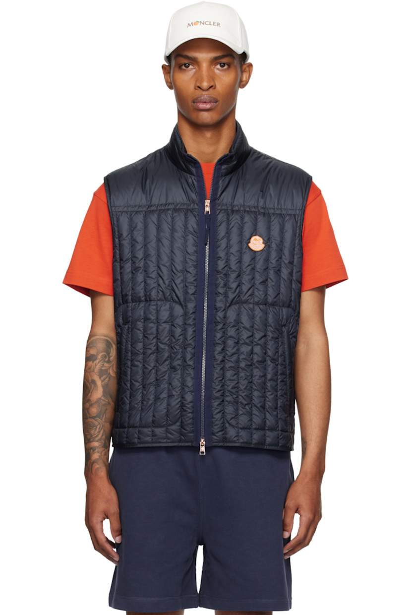 Down-filled and quilted nylon satin vest.

· DIST-certified down
· Stand collar
· Two-way zip closure
· Embroidered logo patch at chest
· Zip pockets
· Fully lined

Part of the Moncler Genius x Gilga Farm collaboration.

Supplier color: Dark navy blue

Fill 1: 90% goose down, 10% feather. Fill 2: 100% polyester.