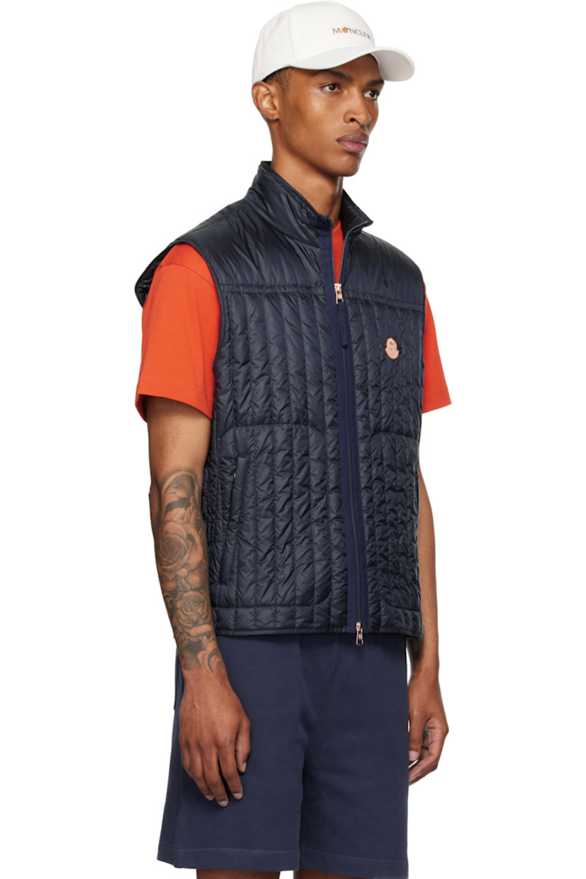 Down-filled and quilted nylon satin vest.

· DIST-certified down
· Stand collar
· Two-way zip closure
· Embroidered logo patch at chest
· Zip pockets
· Fully lined

Part of the Moncler Genius x Gilga Farm collaboration.

Supplier color: Dark navy blue

Fill 1: 90% goose down, 10% feather. Fill 2: 100% polyester.