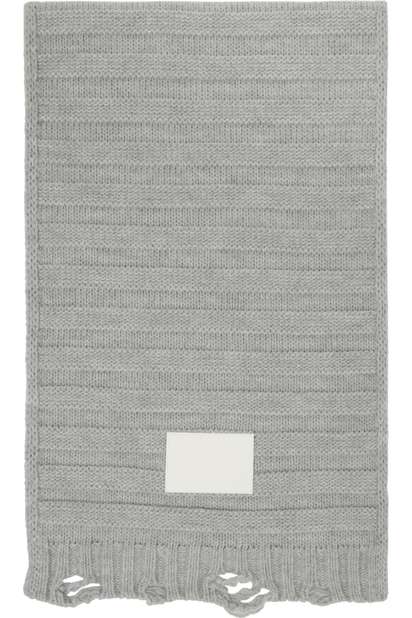 Rectangular 5-gauge knit virgin wool-blend scarf. 

· Logo patch at face
· Raw edge at ends 
· L66" x W16"

Supplier color: Light grey melange