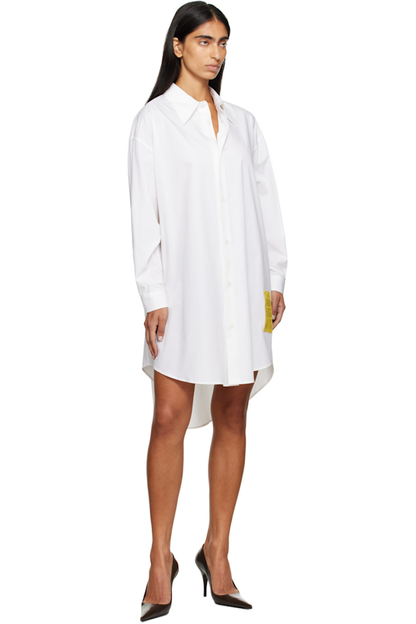 Cotton poplin minidress.

· Spread collar
· Button closure
· Logo patch at front
· Asymmetrical shirttail hem
· Dropped shoulders
· Buttoned barrel cuffs
· Pleats at back yoke
· White stitching at back collar

Supplier color: White
