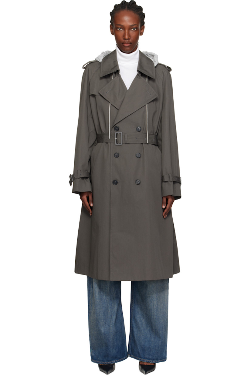 Cotton drill trench coat.

· Drawstring at detachable hood
· Notched lapel
· Double-breasted button closure
· Welt pockets at front
· Belt loops and detachable cinch belt at waist
· Epaulets
· Raglan sleeves
· Pin-buckle tab at cuffs
· White stitching at back collar
· Storm flap at back
· Central vent at back hem
· Welt pocket at interior
· Full satin lining

Supplier color: Grey