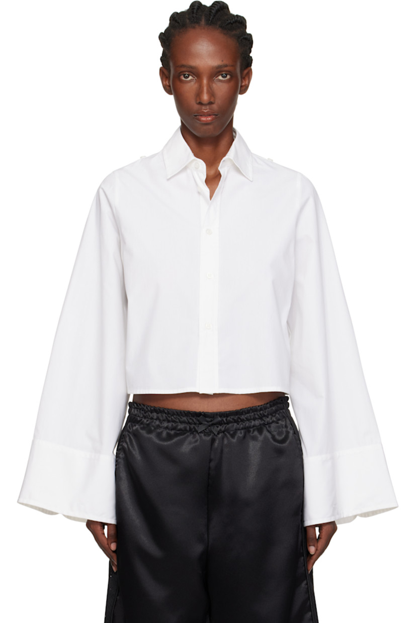 Cotton poplin shirt. 

· Spread collar
· Button closure
· Cropped hem 
· Button hardware at shoulders
· Buttoned barrel cuffs
· White stitching at back collar 

Supplier color: White