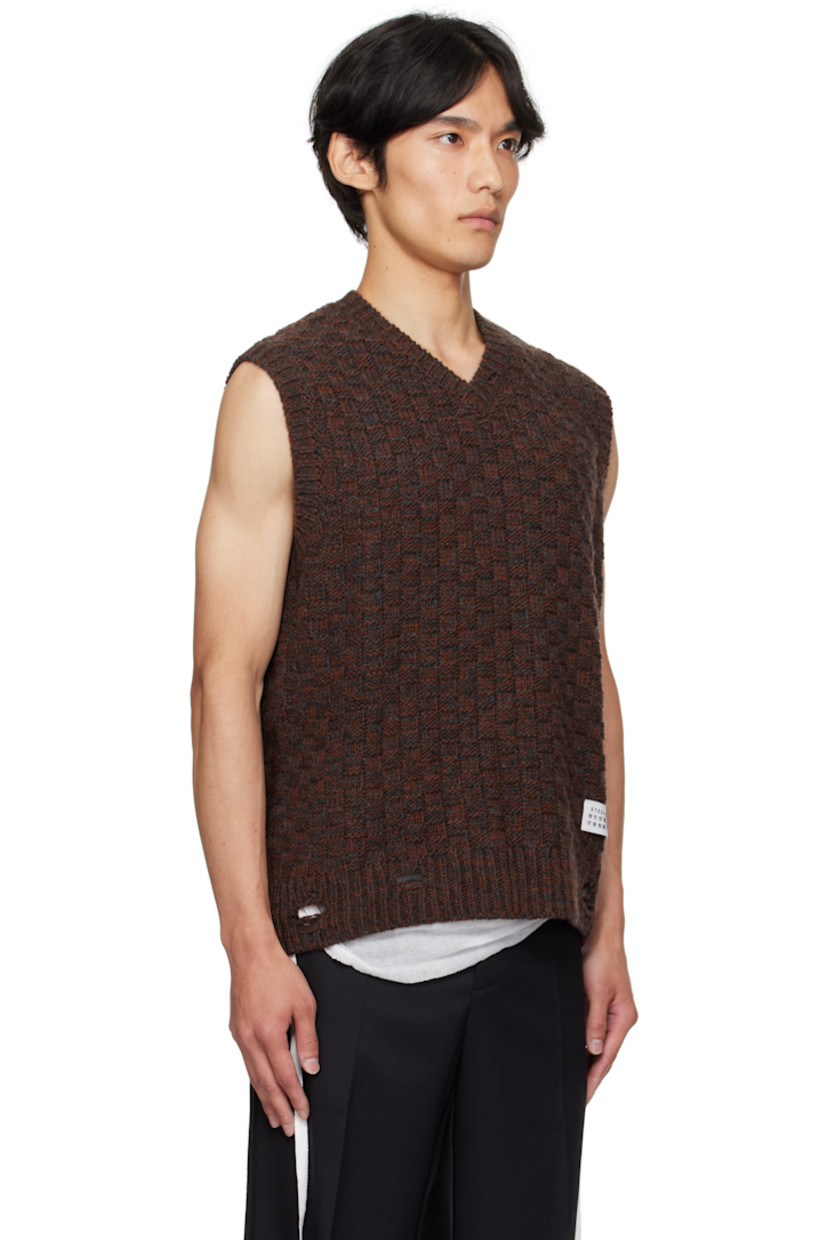 Knit virgin wool-blend sweater vest.

· Jacquard check pattern throughout 
· Rib-knit V-neck, hem, and armscyes
· Logo patch at front hem 
· White stitching at back collar 

Supplier color: Dark grey melange