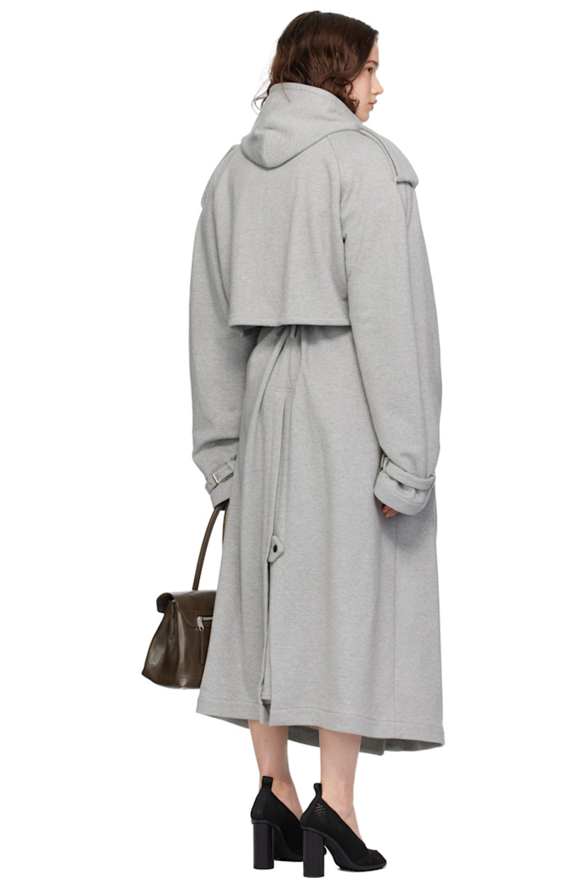 French terry trench coat. 

· Hood at notched lapel 
· Hook-eye fastening at lapel 
· Double-breasted button closure
· Button-down storm flaps at chest
· Welt pockets
· Belt loops and detachable self-tie belt 
· Epaulets 
· Raglan sleeves
· Storm flap at back 
· Central expansion panel with button tab at back hem 

Supplier color: Grey