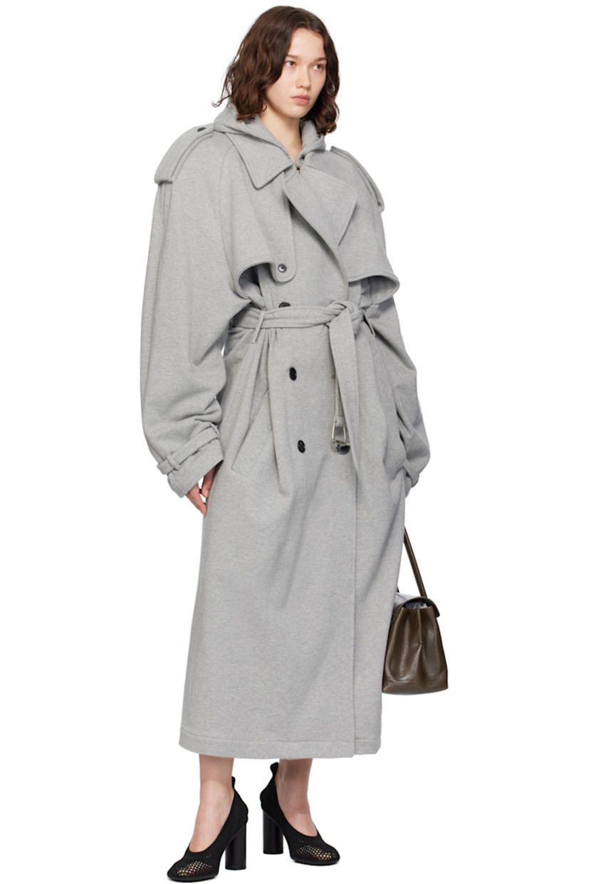 French terry trench coat. 

· Hood at notched lapel 
· Hook-eye fastening at lapel 
· Double-breasted button closure
· Button-down storm flaps at chest
· Welt pockets
· Belt loops and detachable self-tie belt 
· Epaulets 
· Raglan sleeves
· Storm flap at back 
· Central expansion panel with button tab at back hem 

Supplier color: Grey