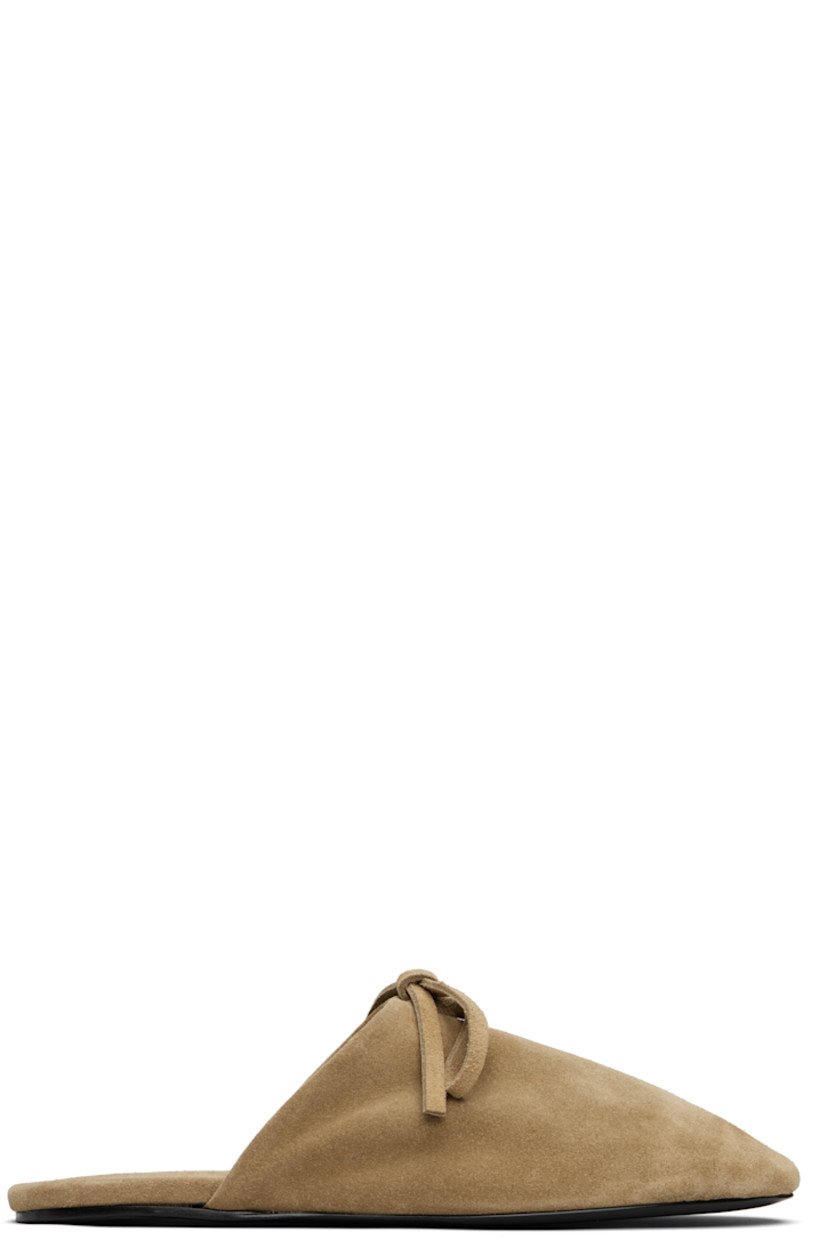 Suede slippers.

· Bow accent at vamp
· Logo embossed at padded footbed
· Leather sole with rubber injection

Supplier color: Beige