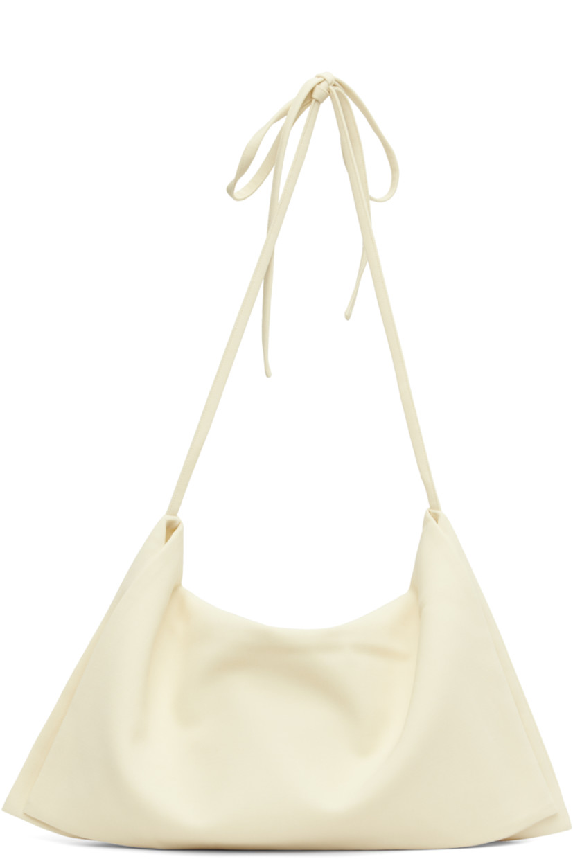Virgin wool twill shoulder bag.

· Foldover construction 
· Adjustable self-tie crossbody strap
· Zip closure
· Silk satin lining
· Mulesing-free wool
· H22.5" x W18.5" 

Supplier color: Off white
