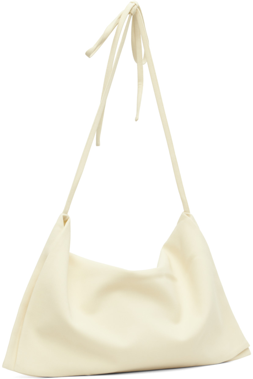 Virgin wool twill shoulder bag.

· Foldover construction 
· Adjustable self-tie crossbody strap
· Zip closure
· Silk satin lining
· Mulesing-free wool
· H22.5" x W18.5" 

Supplier color: Off white