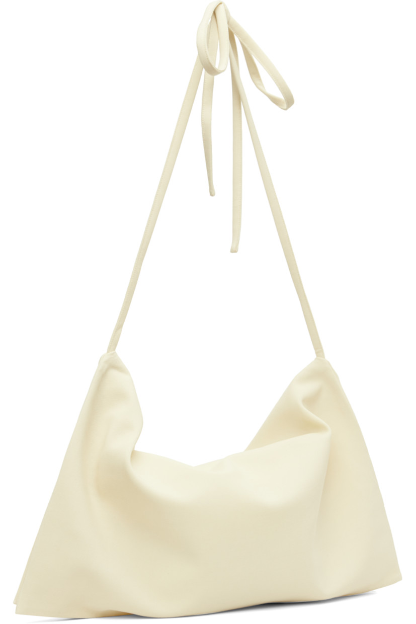 Virgin wool twill shoulder bag.

· Foldover construction 
· Adjustable self-tie crossbody strap
· Zip closure
· Silk satin lining
· Mulesing-free wool
· H22.5" x W18.5" 

Supplier color: Off white