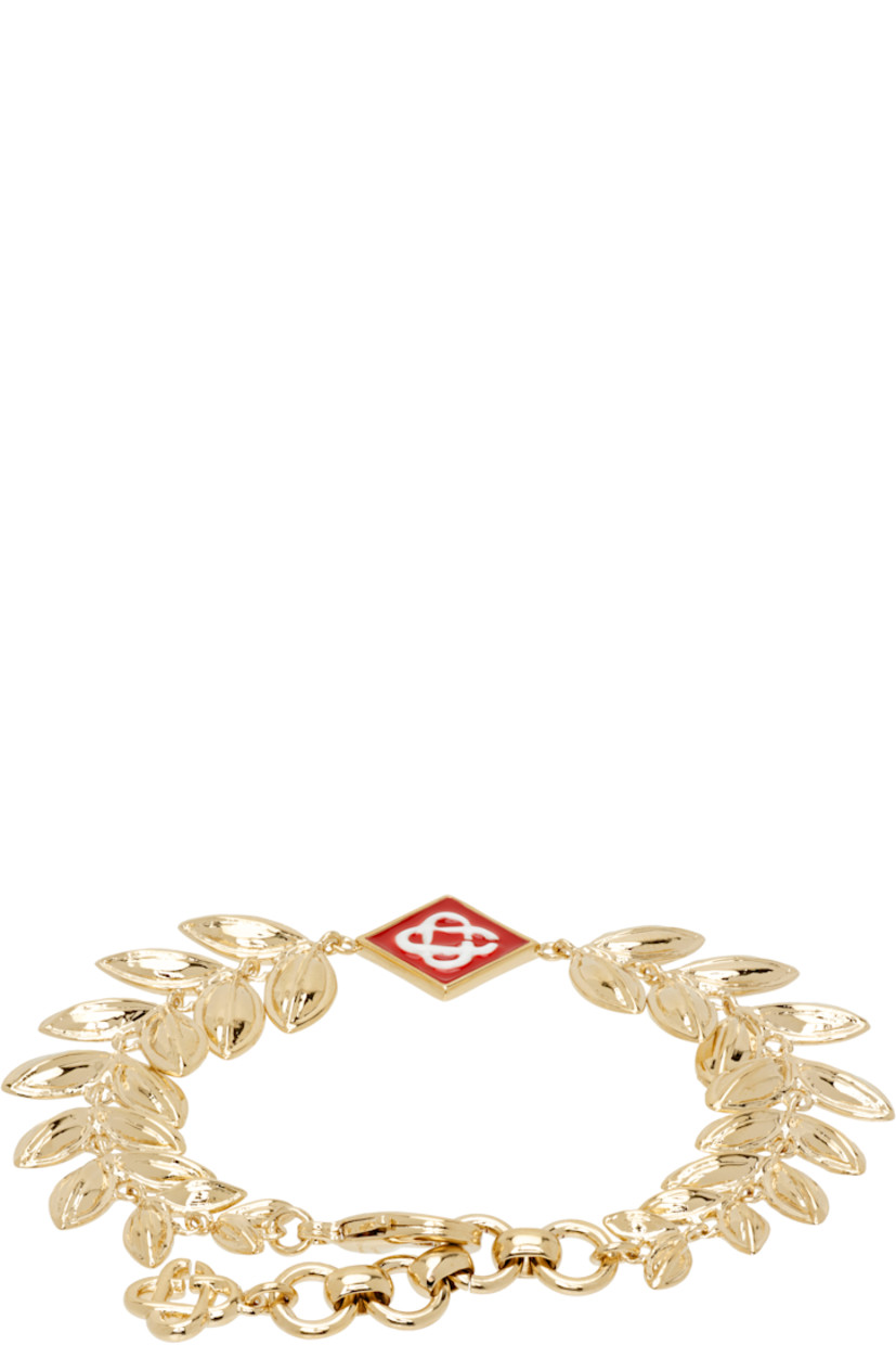 Modified cable chain bracelet in gold-tone brass.

· Enameled logo charm at face
· Logo charm at adjustable lobster clasp 
· L8"

Supplier color: Gold/Red