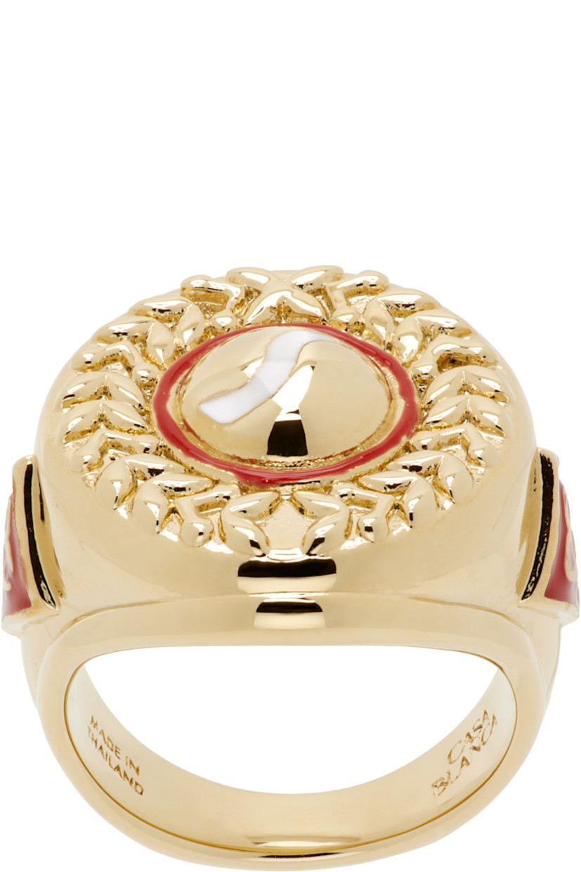Signet ring in gold-tone brass.

· Enamel and engraved graphics at face 
· Enameled logo at sides

Supplier color: Gold/Red