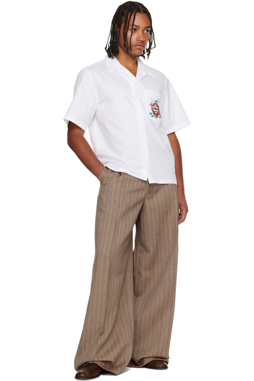 Cotton poplin shirt. 

· Open spread collar 
· Button closure 
· Embroidered logo graphic at patch pocket 
· Tennis-tail hem 

Supplier color: White