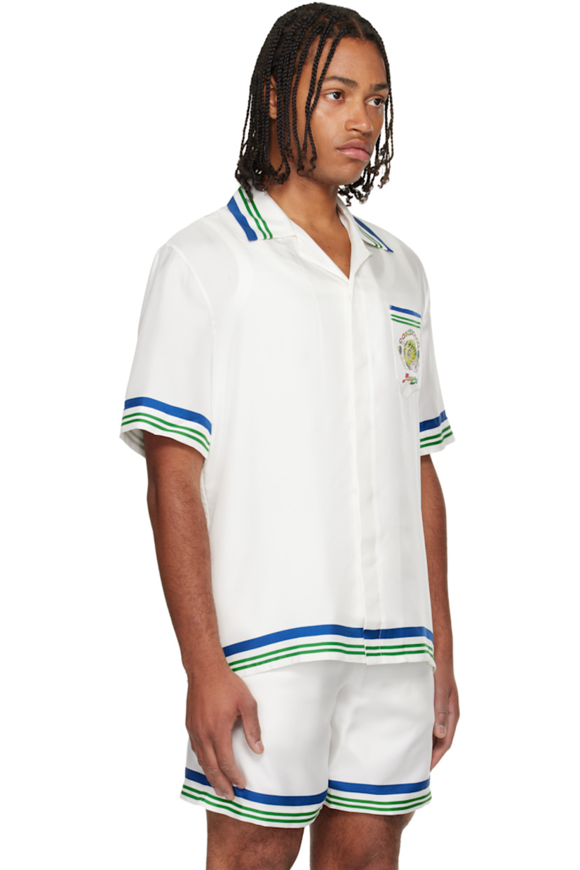 Silk twill shirt. 

· Stripes at collar, hem, and cuffs 
· Button tab at open spread collar 
· Button closure 
· Patch pocket at chest 
· Logo graphic printed at chest and back

Supplier color: White