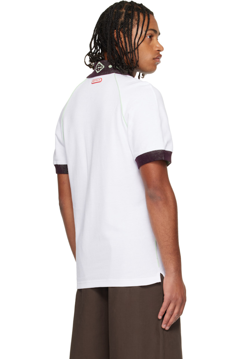 Textured cotton piqué polo.

· Piping throughout 
· Jacquard logo pattern at rib-knit chenille spread collar 
· Three-button placket 
· Rubber logo appliqués at chest and back collar 
· Vented side seams 
· Raglan sleeves 
· Rib-knit chenille cuffs

Supplier color: White