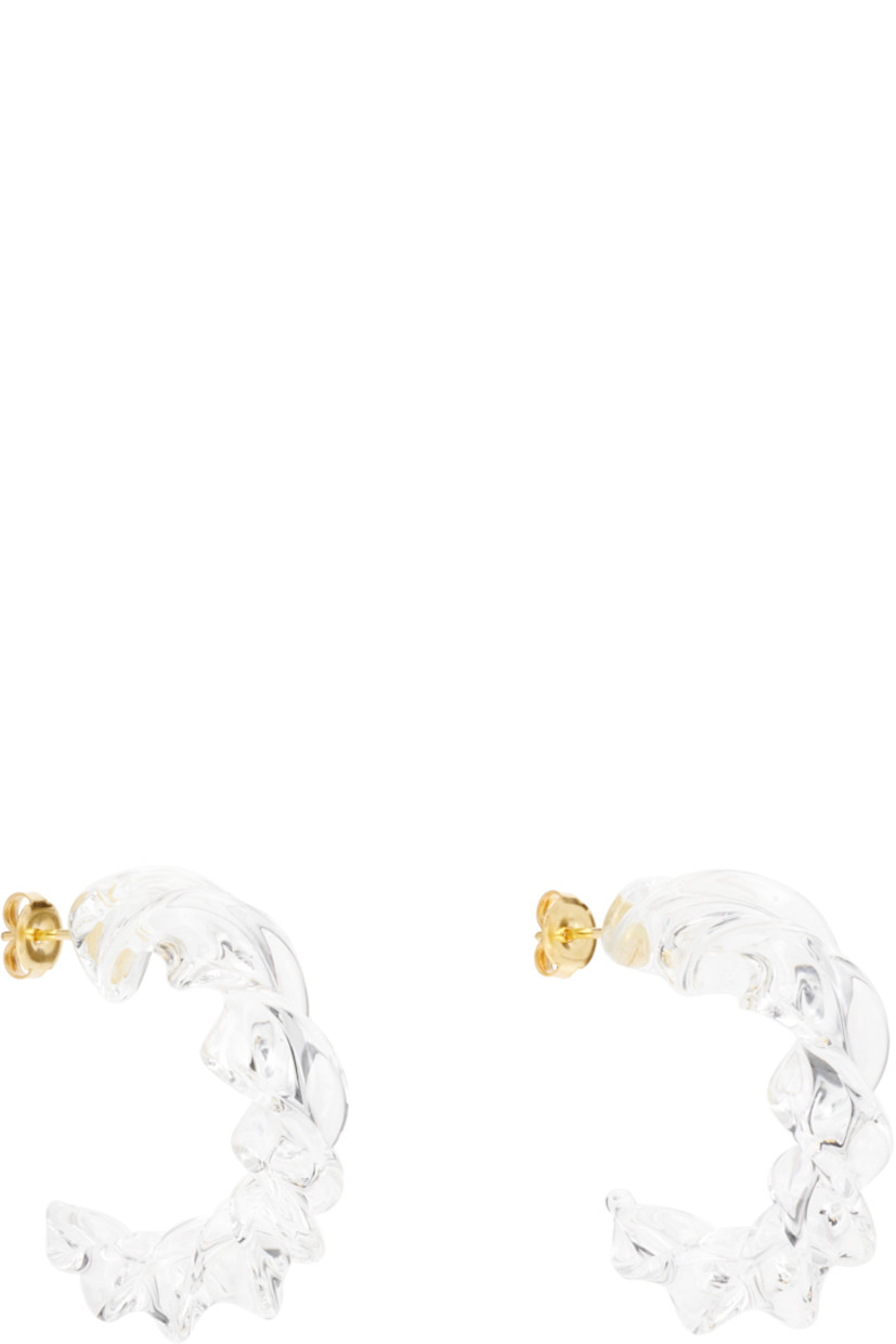Pair of handcrafted open hoop earrings in transparent borosilicate glass.

· Twisted detailing throughout 
· Post-stud fastening 
· Gold-tone brass hardware
· D1.5"

Supplier color: Clear