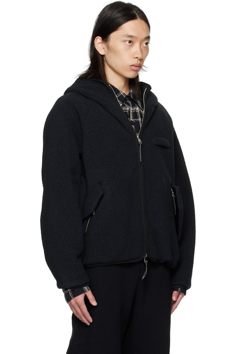 Sherpa fleece jacket. 

· Two-way zip closure
· Strap at chest 
· Flap pockets at waist 
· Bungee-style drawstring at hem 
· Raglan sleeves
· Elasticized cuffs
· Welt pockets at interior 
· Twill lining

Supplier color: Black