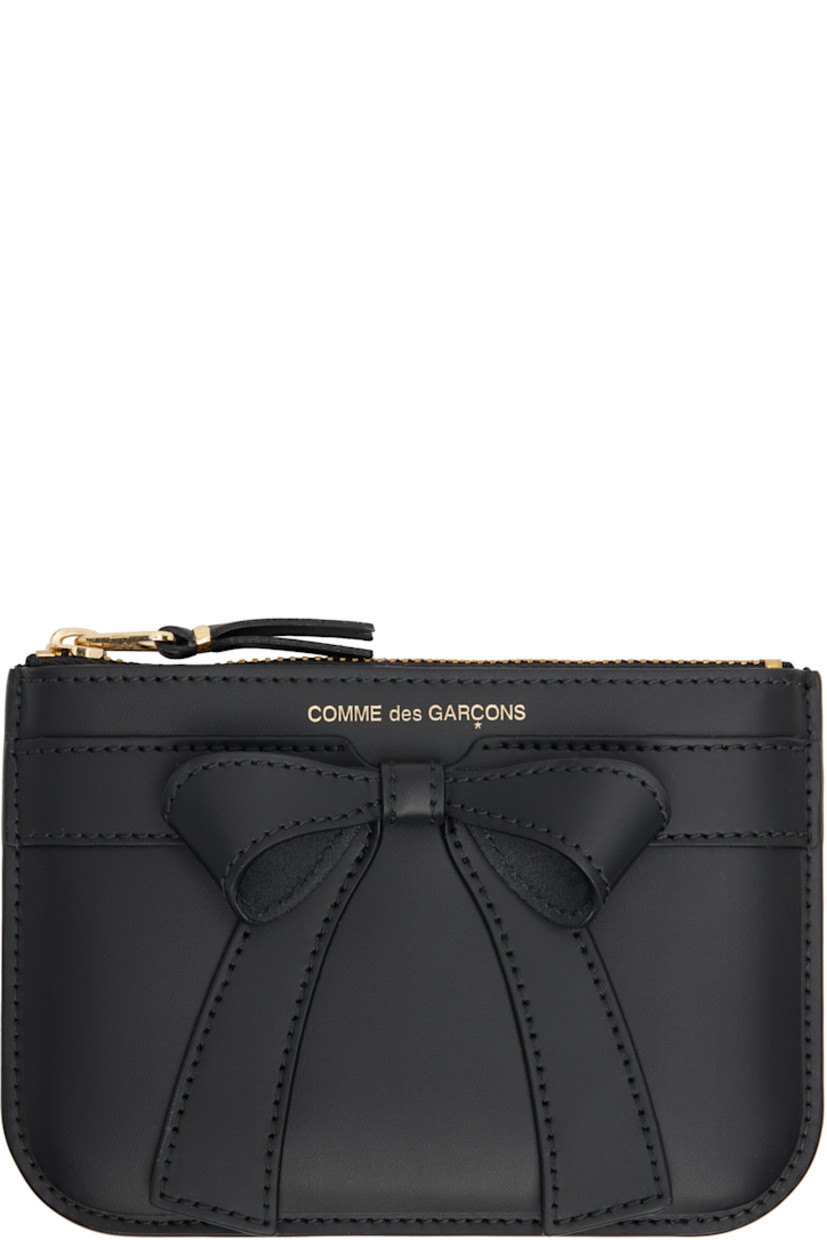 Buffed leather wallet in black.

· Logo stamp and bow accent at face
�· Zip closure
· Grained leather lining
· H4.25" x W6"

Supplier color: Black
